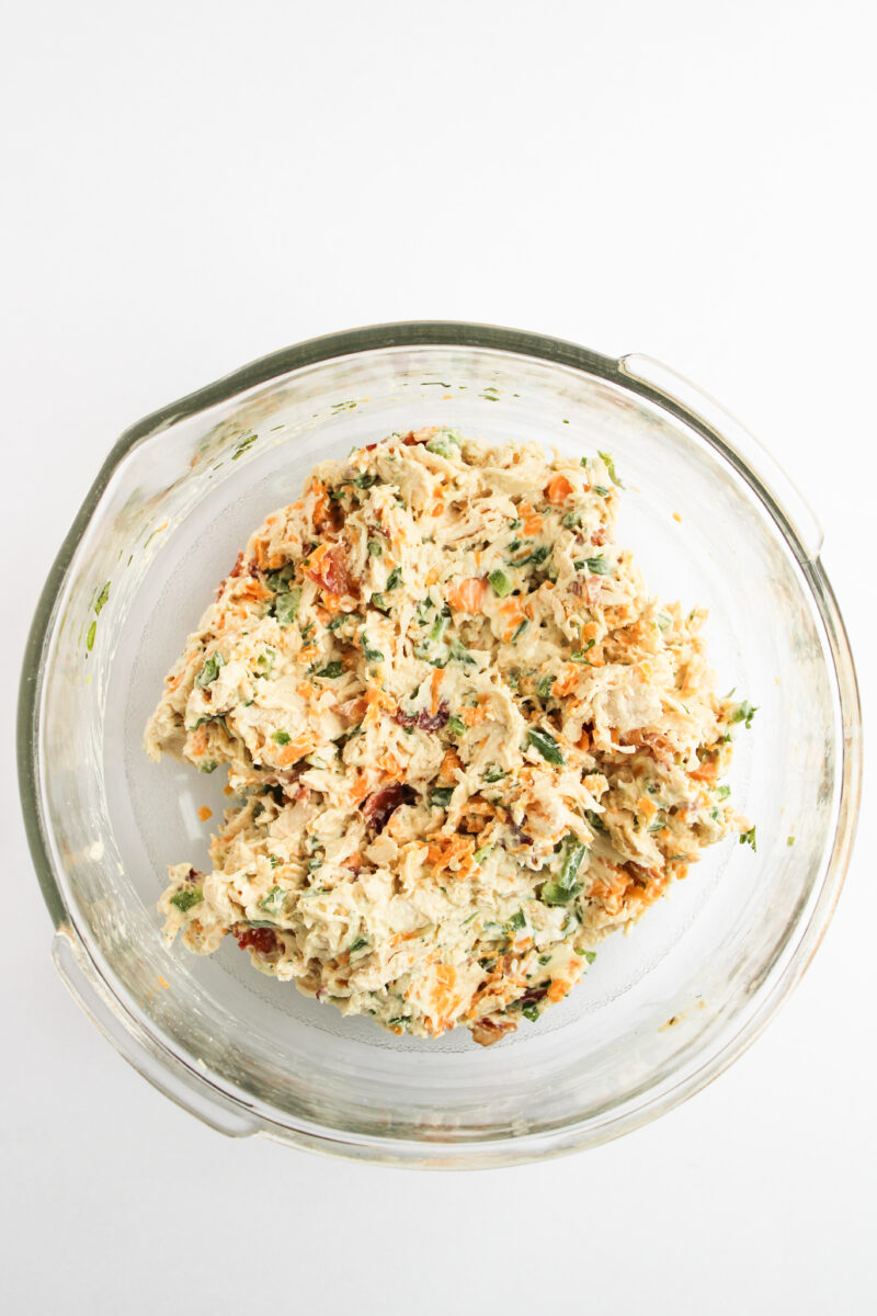 Chicken salad mixed together in a clear bowl.