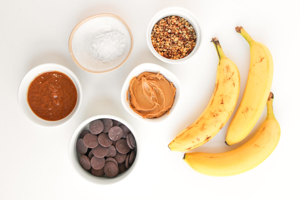 Ingredients for banana snickers bites layed on white background