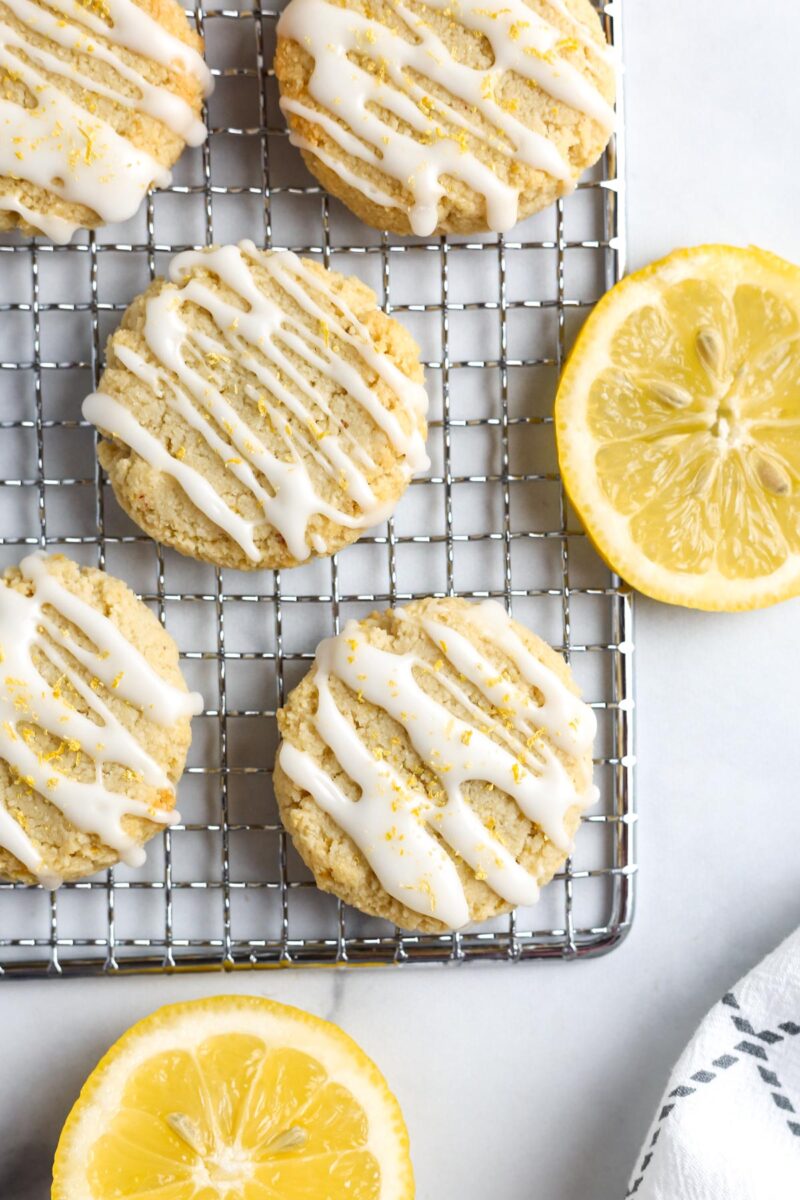 lemon cookies with white glaze and lemon zest on a wire cooling rack