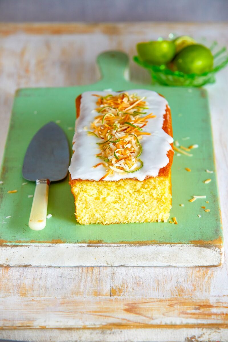sliced lime coconut cake with cream frosting and lime zest