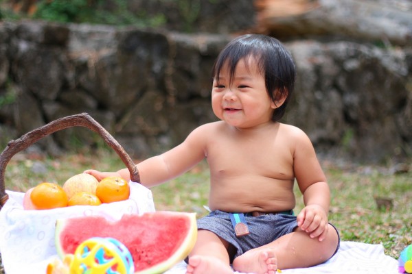 Happy kid eating healthy naturally sweet snack (fruit).