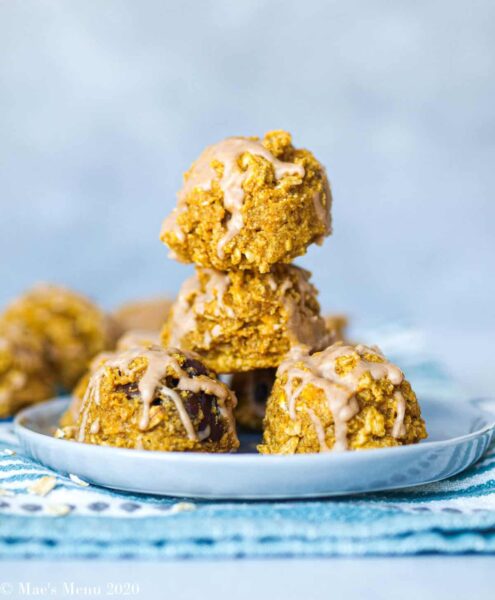 stacked pumpkin oatmeal cookies with white glazed on a white saucer plate