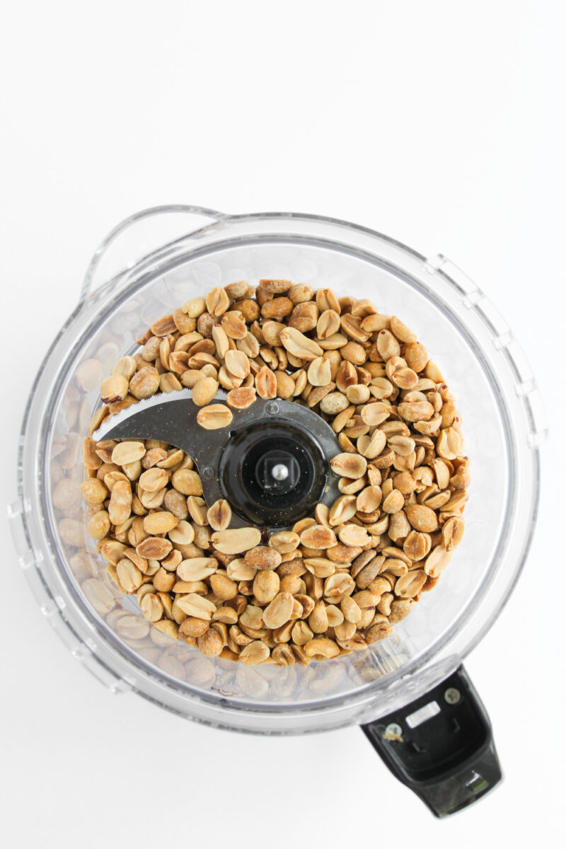 Peanuts in food processor on white background.