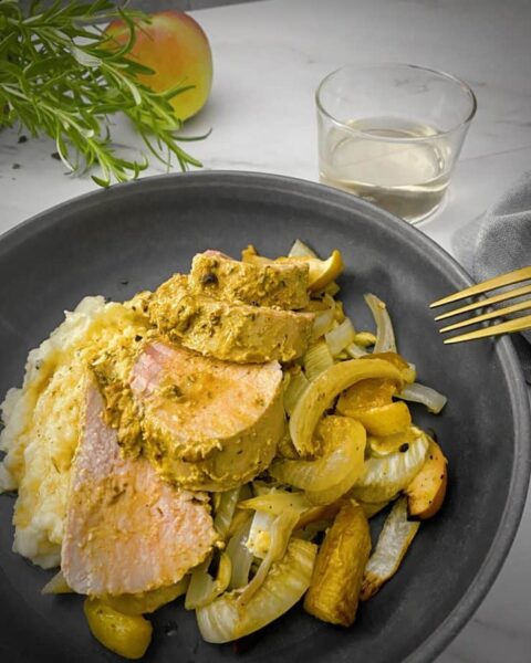 Roasted Pork Tenderloin with Mustard & Roasted Apples and Fall Vegetables served with mashed potatoes on a gray plate