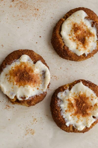 gluten free pumpkin thumbprint cookies topped with creamcheese sprinkled with cinnamon sugar