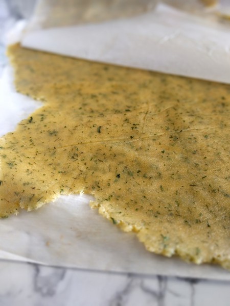 I try to get my cracker dough to be about 1/8" everywhere. Roll it between two pieces of parchment for non-stick rolling.