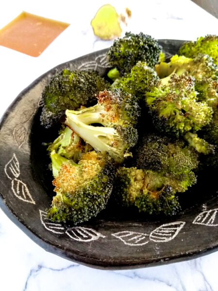 oven roasted broccoli on black plate