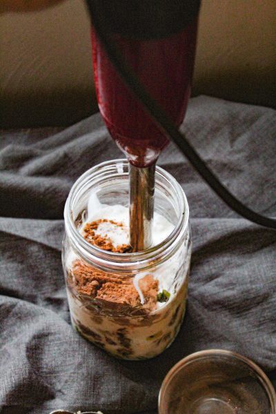 Blending the smoothie mixture in a mason jar