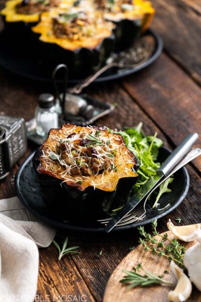 acorn stuffes with sauge cranberries and herbs on a small black plate