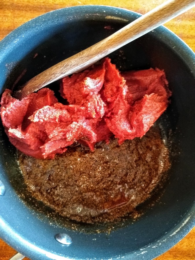 Add tomato paste to spice, oil mixture